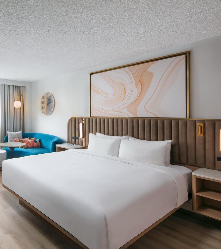 Upholstered headboard with soft lighting and integrated nightstands at sonesta miami hotel