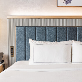 A bed headboard with fine detailing including leather and metal insets