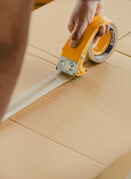 A worker taping up a cardboard box