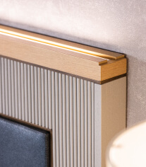 A bed headboard with fine routing, and brass and LED inlay work