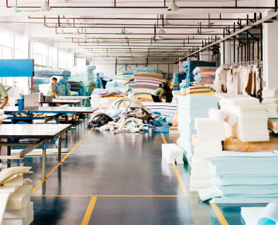 Factory workers cutting foam for use in a sofas