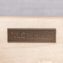 TLC Hospitality logo set in brass in a case good drawer