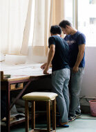 Production team discussing furniture drawings in the factory