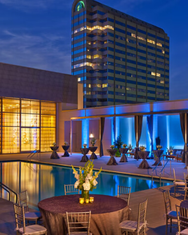 A hotel terrace featuring a swimming pool and a dining area