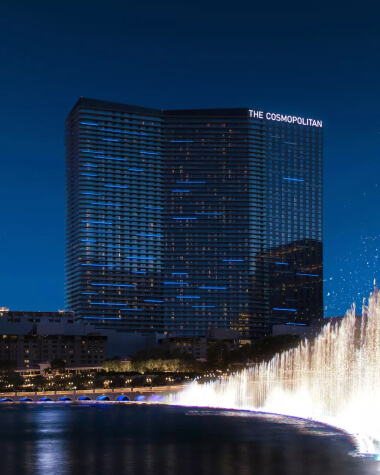 A high-rise hotel with fountains in front